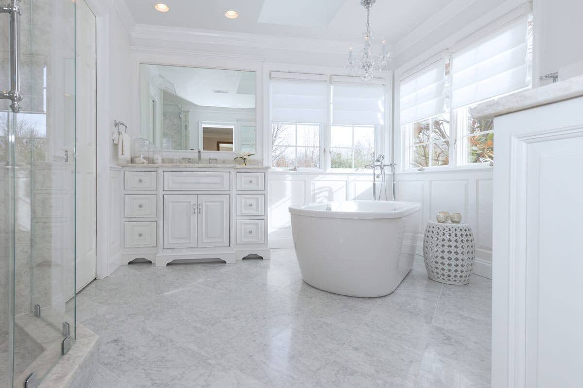 Bathroom with Antartide vanity tops, a freestanding tub, and a glass shower