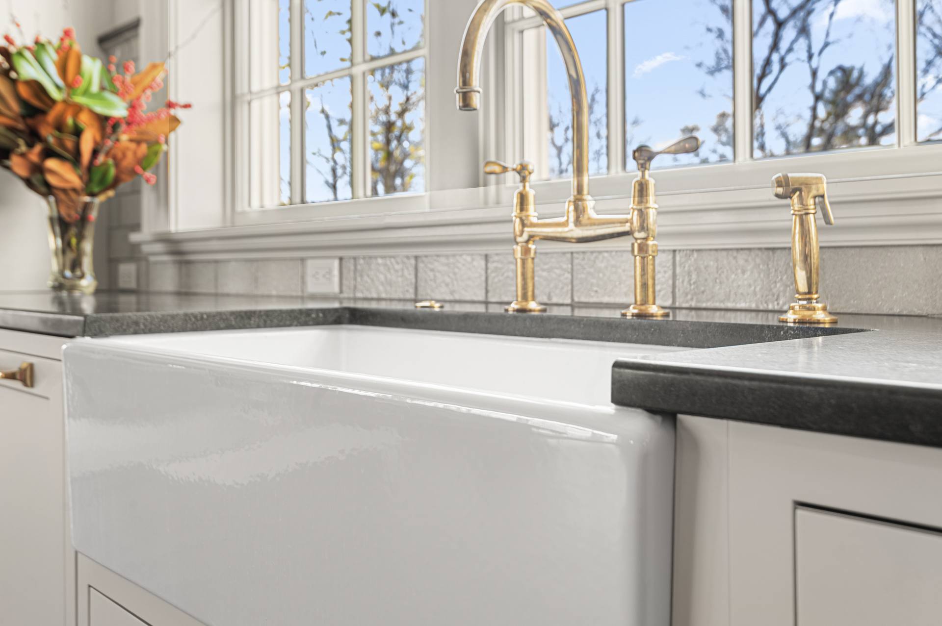 White farmhouse apron sink set into a Black Absolute granite counter