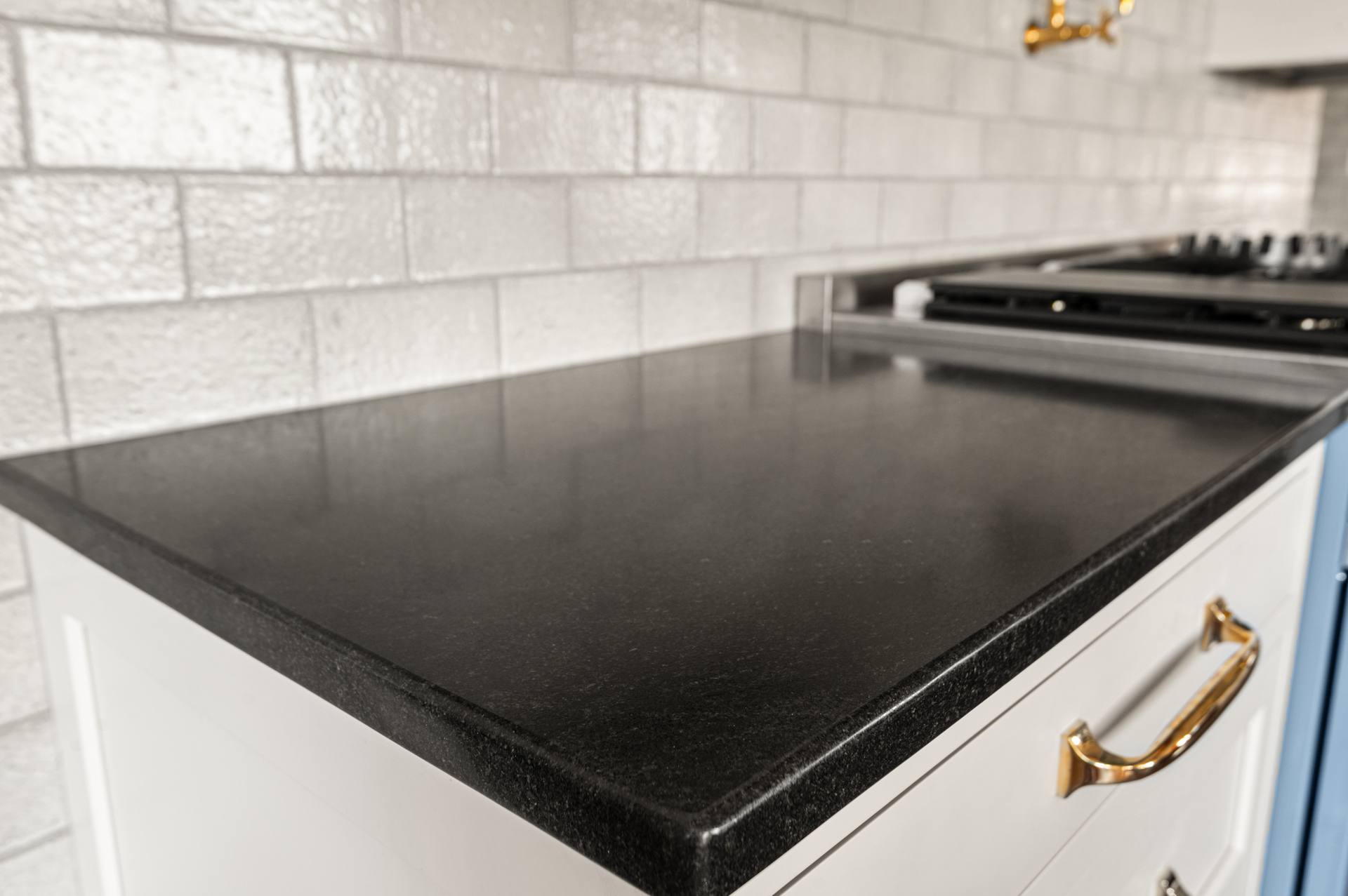 Thick rounded edge on a Black Absolute granite counter beside a cooktop