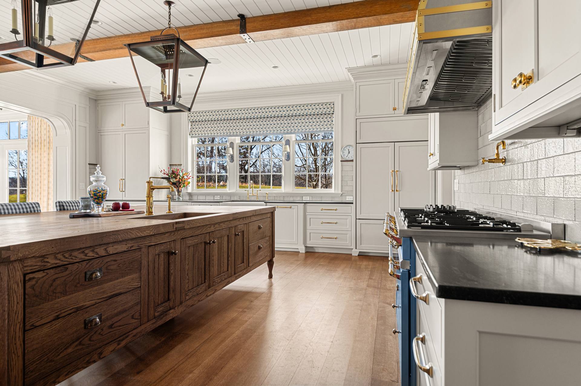 Black Absolute granite counters running past a wood island toward a blue range