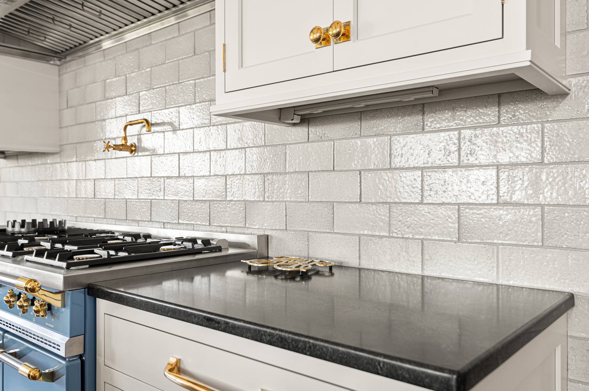 Black Absolute granite counter beside a blue range and white tile