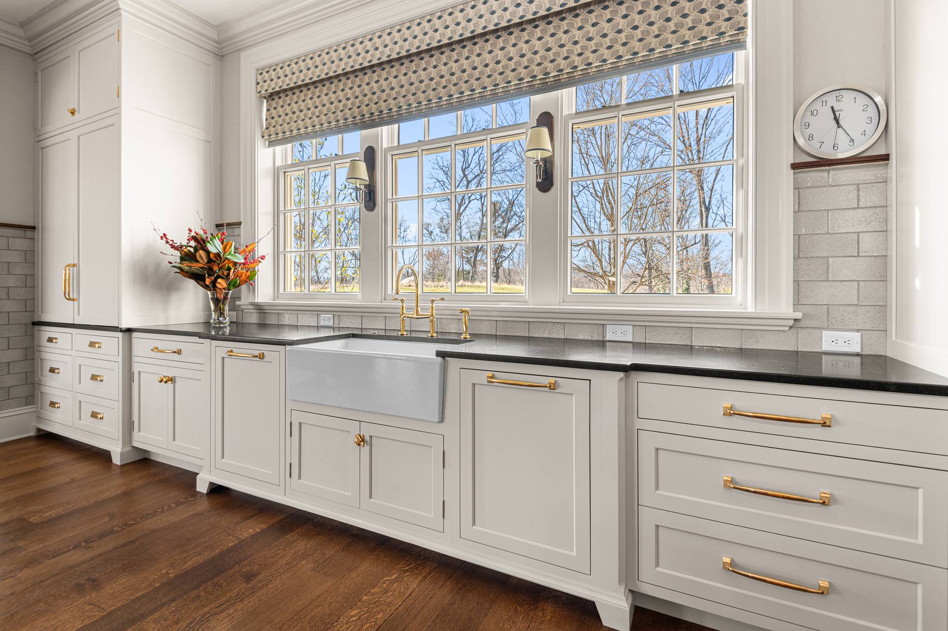 Black Absolute granite counter below windows with a farmhouse apron sink