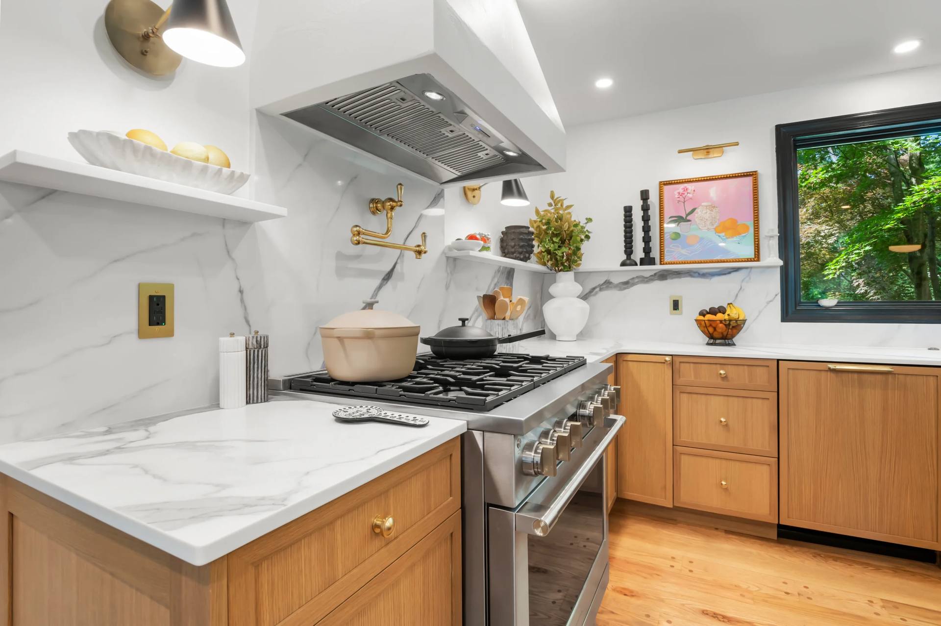 Full-height Calacatta Corchia quartz backsplash behind a metal range