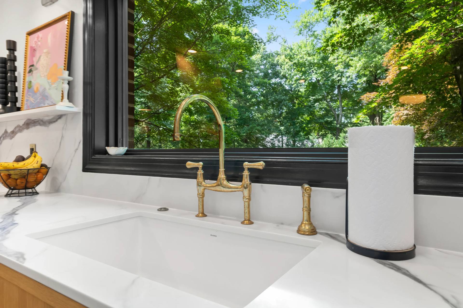Undermount sink and gold-tone bridge faucet in a Calacatta Corchia quartz countertop