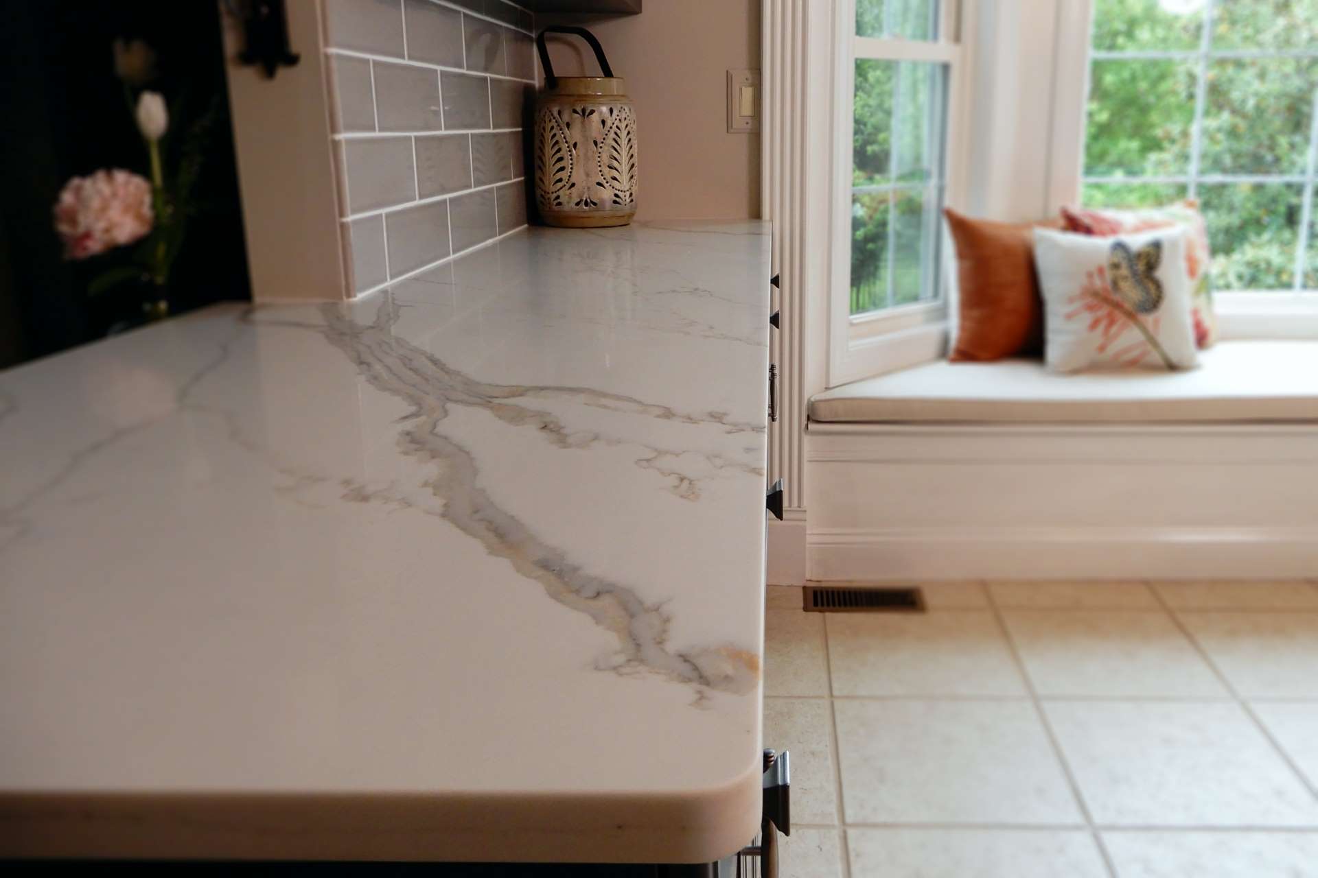 Close view of Calacatta Gold quartz veining beside a kitchen window