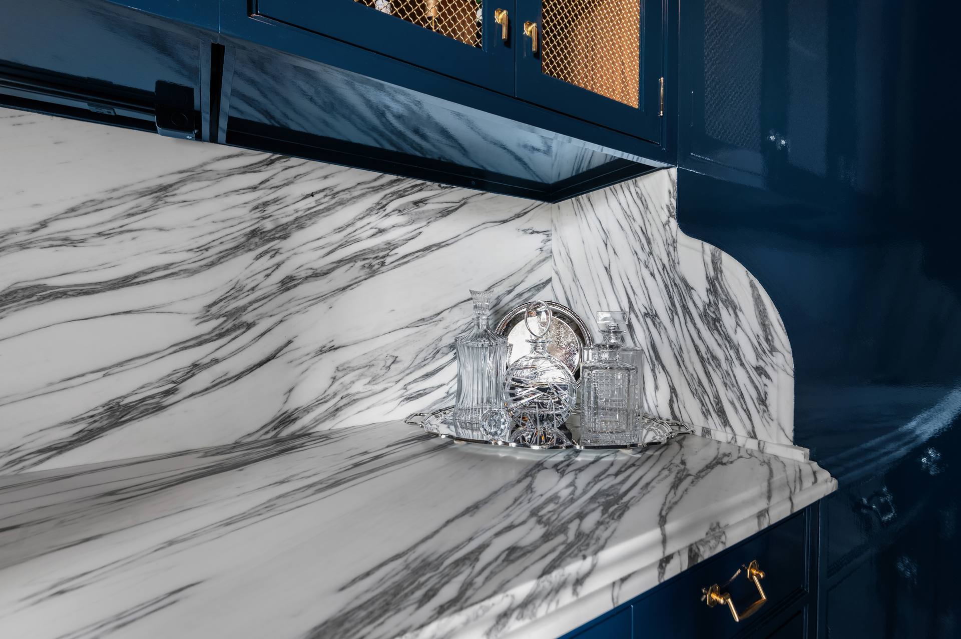 Calacatta Corchia marble bar counter with crystal glassware on a tray