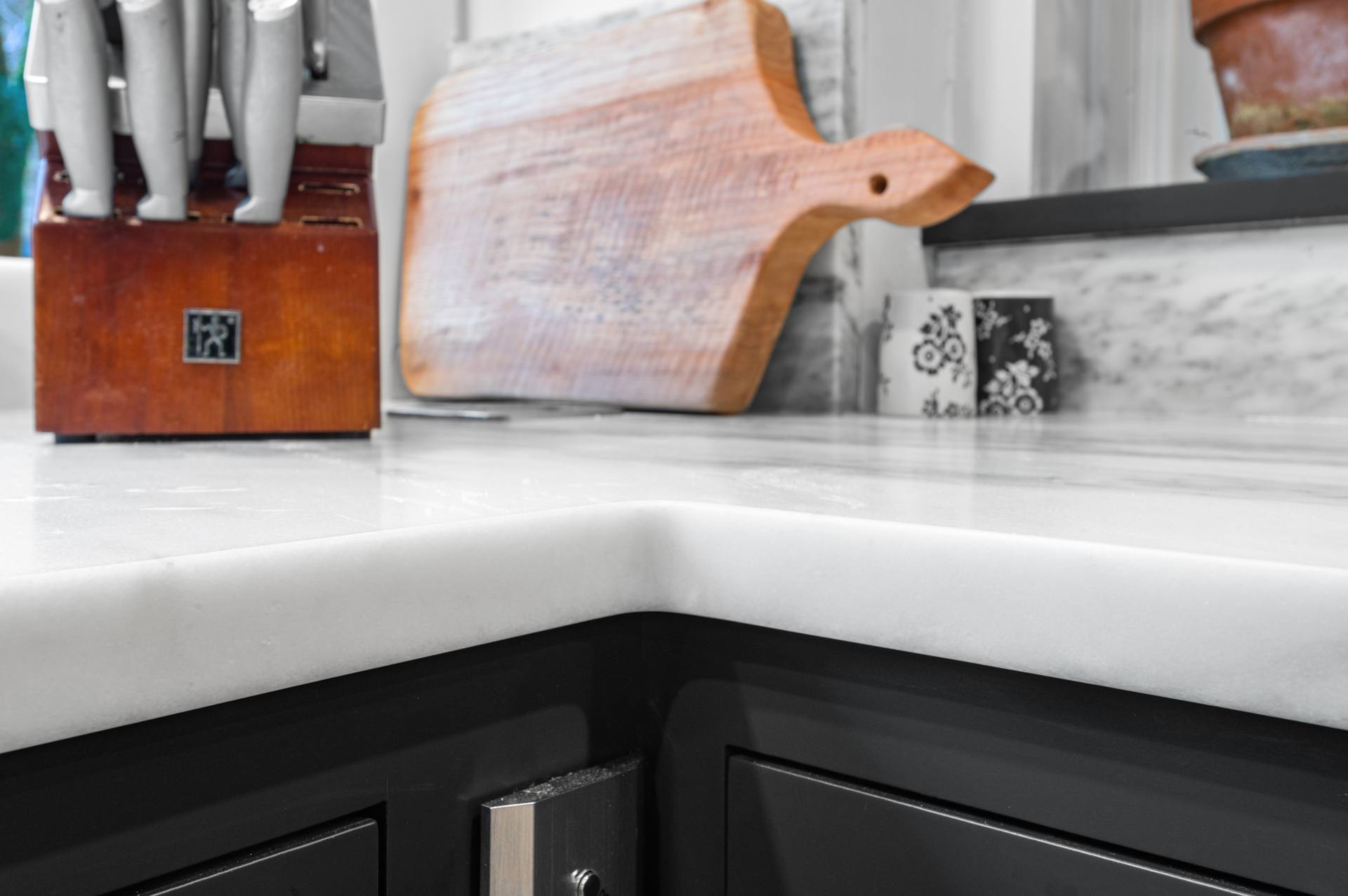 Corner of a honed Danby marble counter above dark cabinets