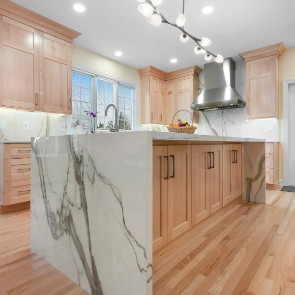 Calacatta Gold porcelain kitchen island with light wood cabinets