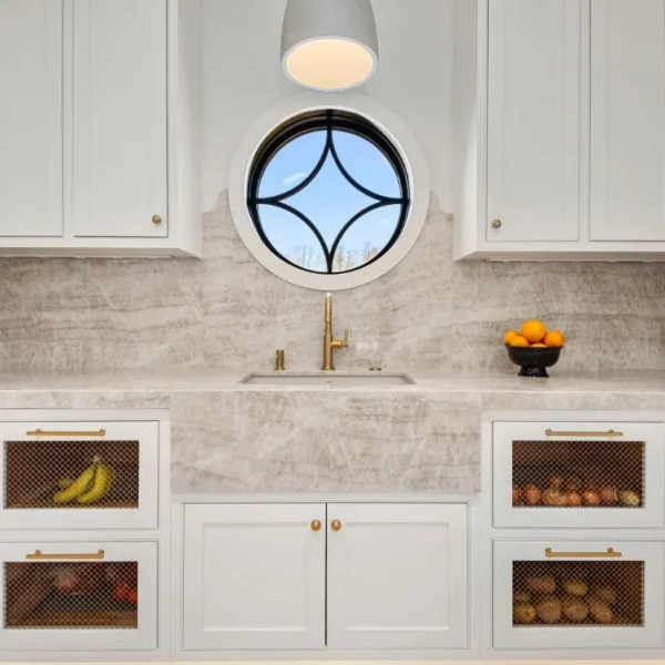 Taj Mahal quartzite countertops beneath a round kitchen window