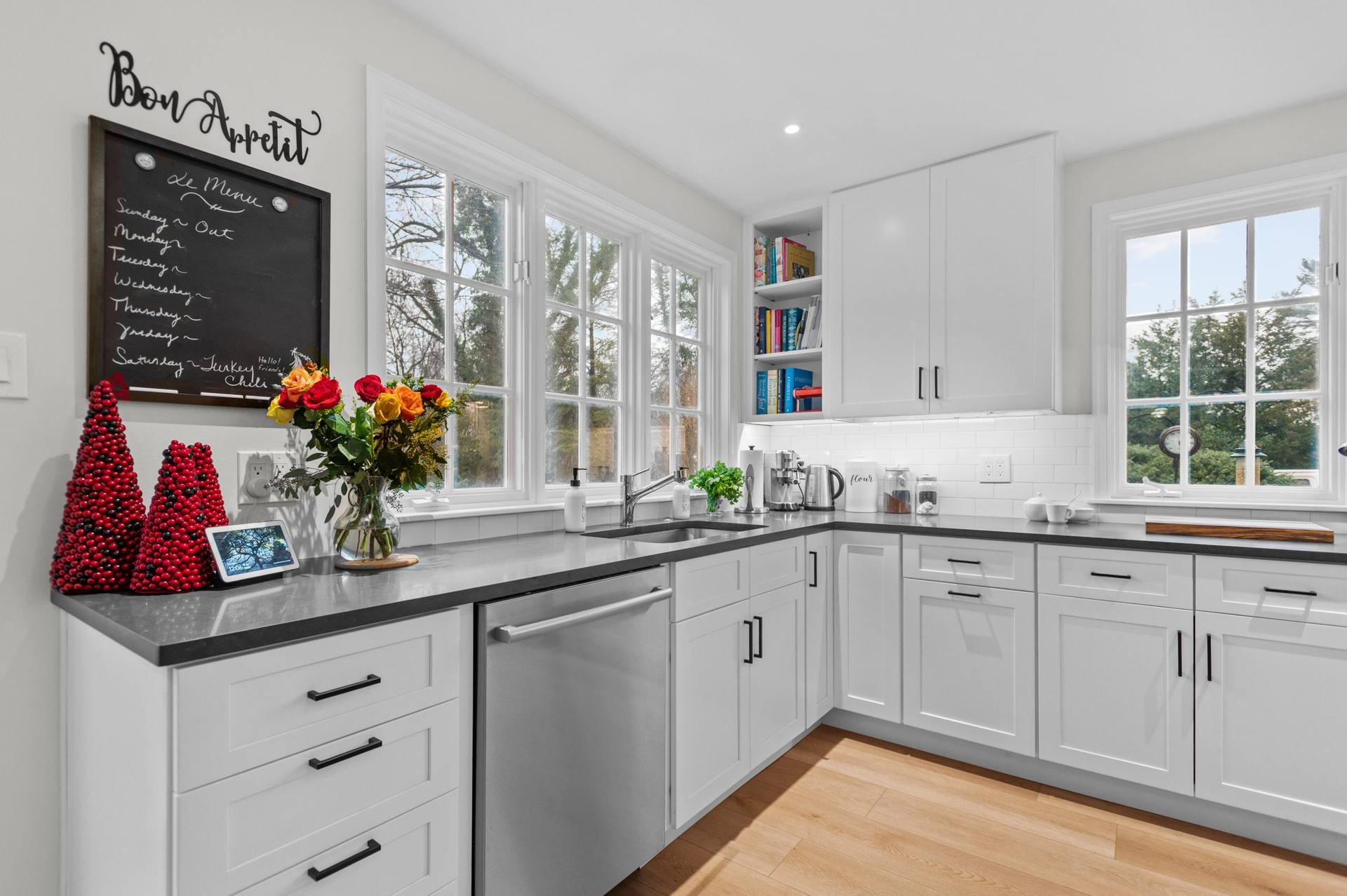 Dark perimeter counter and white cabinets beside subway tile