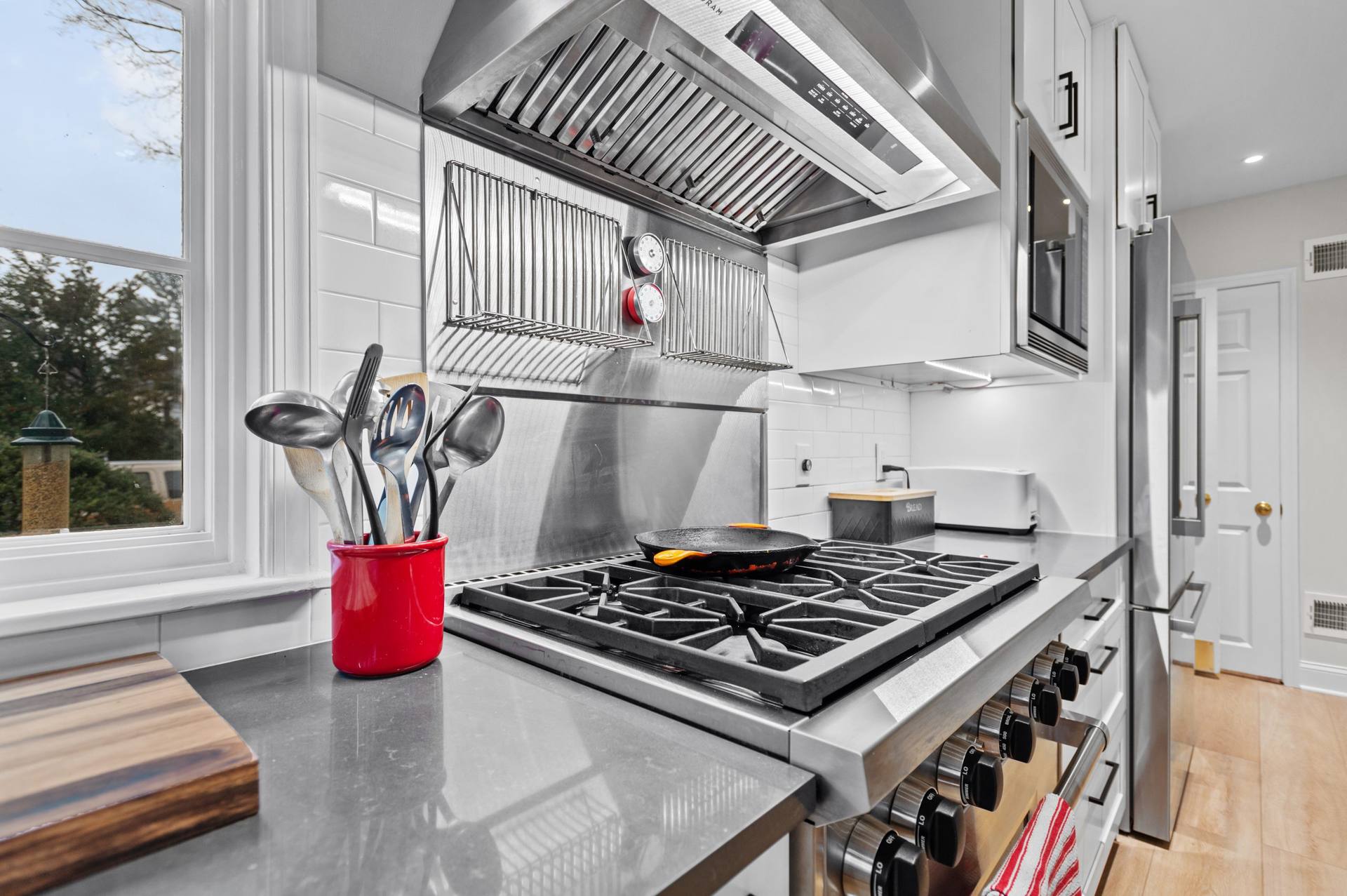 Metal range and hood above a dark perimeter counter