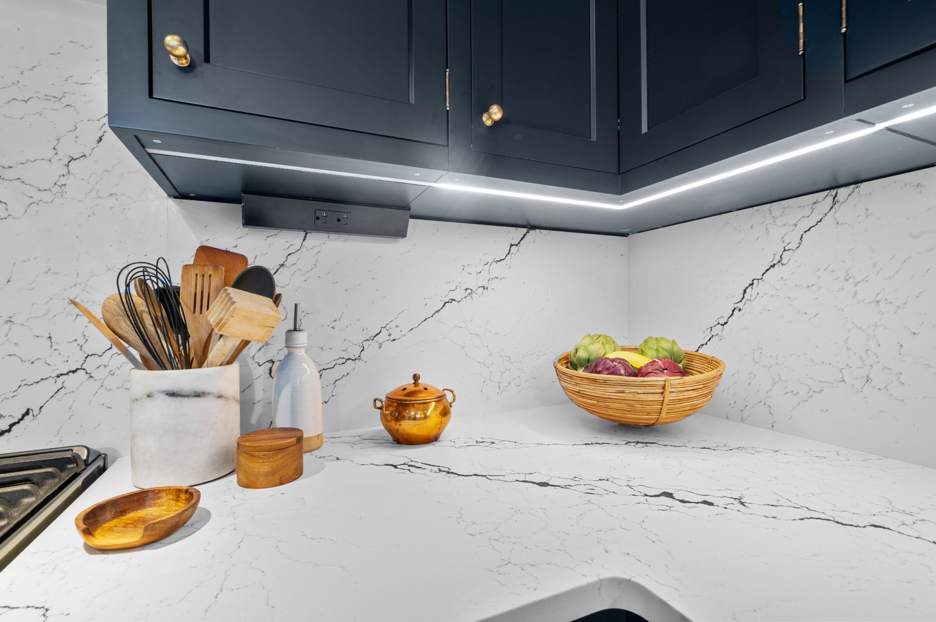 Cambria Inverness Platinum quartz countertops and full-height backsplash beneath dark cabinets