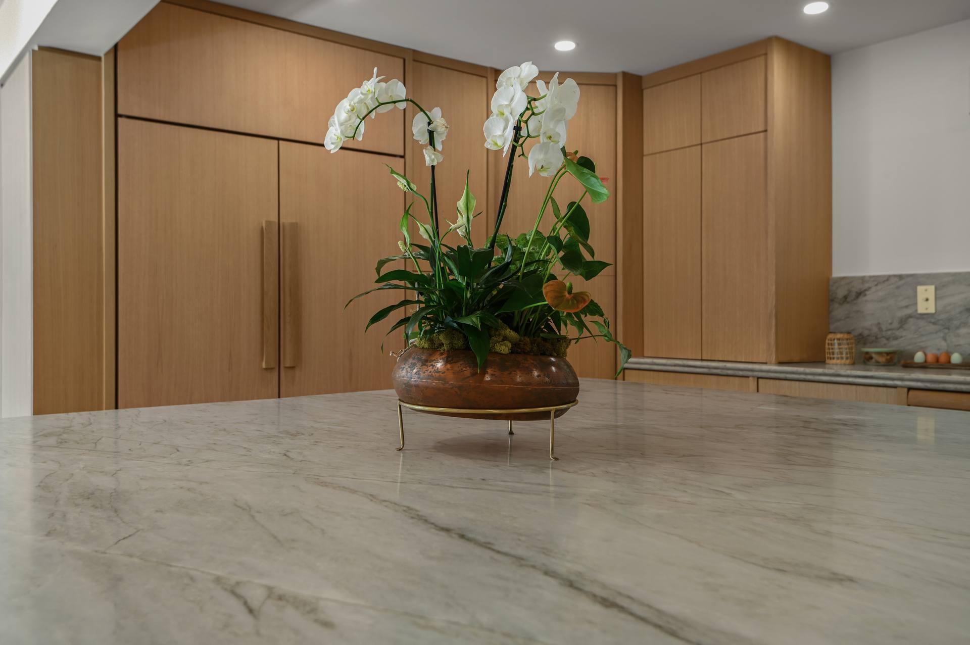 Leathered Sea Pearl quartzite island surface with an orchid centerpiece