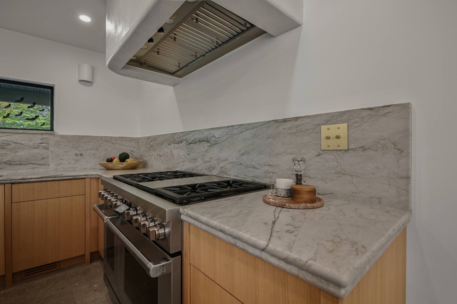 Sea Pearl quartzite counter wrapping a corner beside the range, with a quartzite backsplash