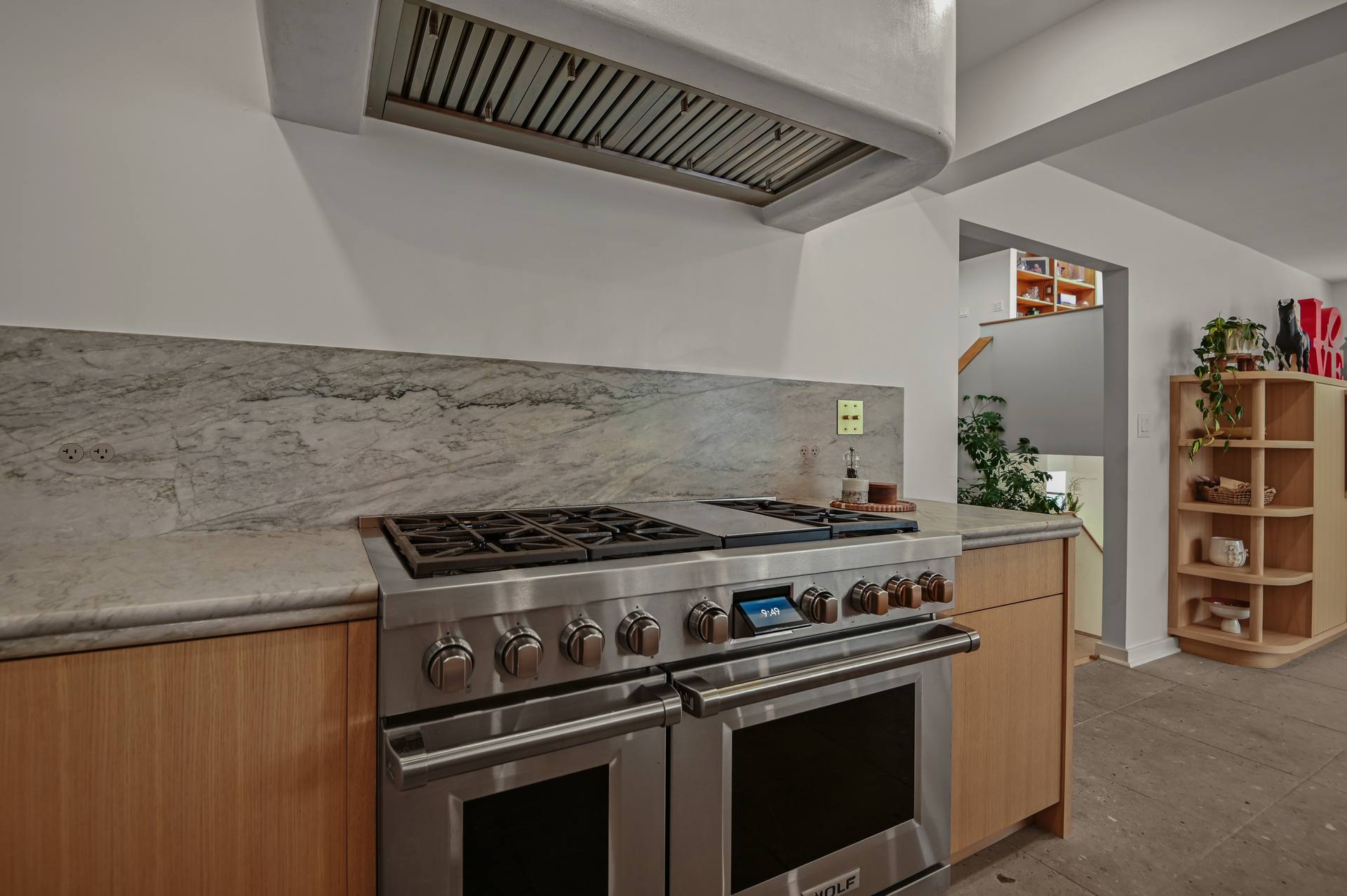 Professional-style range between Sea Pearl quartzite counters with a quartzite backsplash