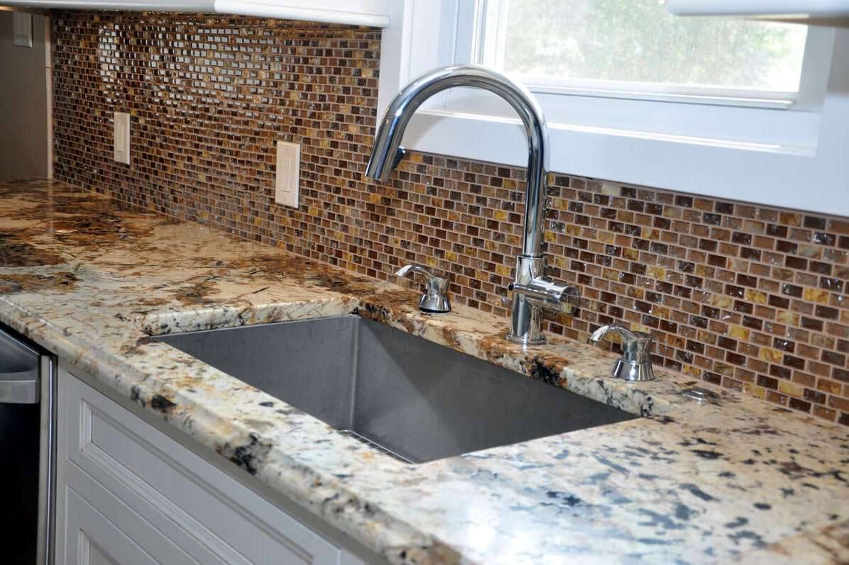 Undermount sink and silver-tone faucet in leathered Splendor Gold granite