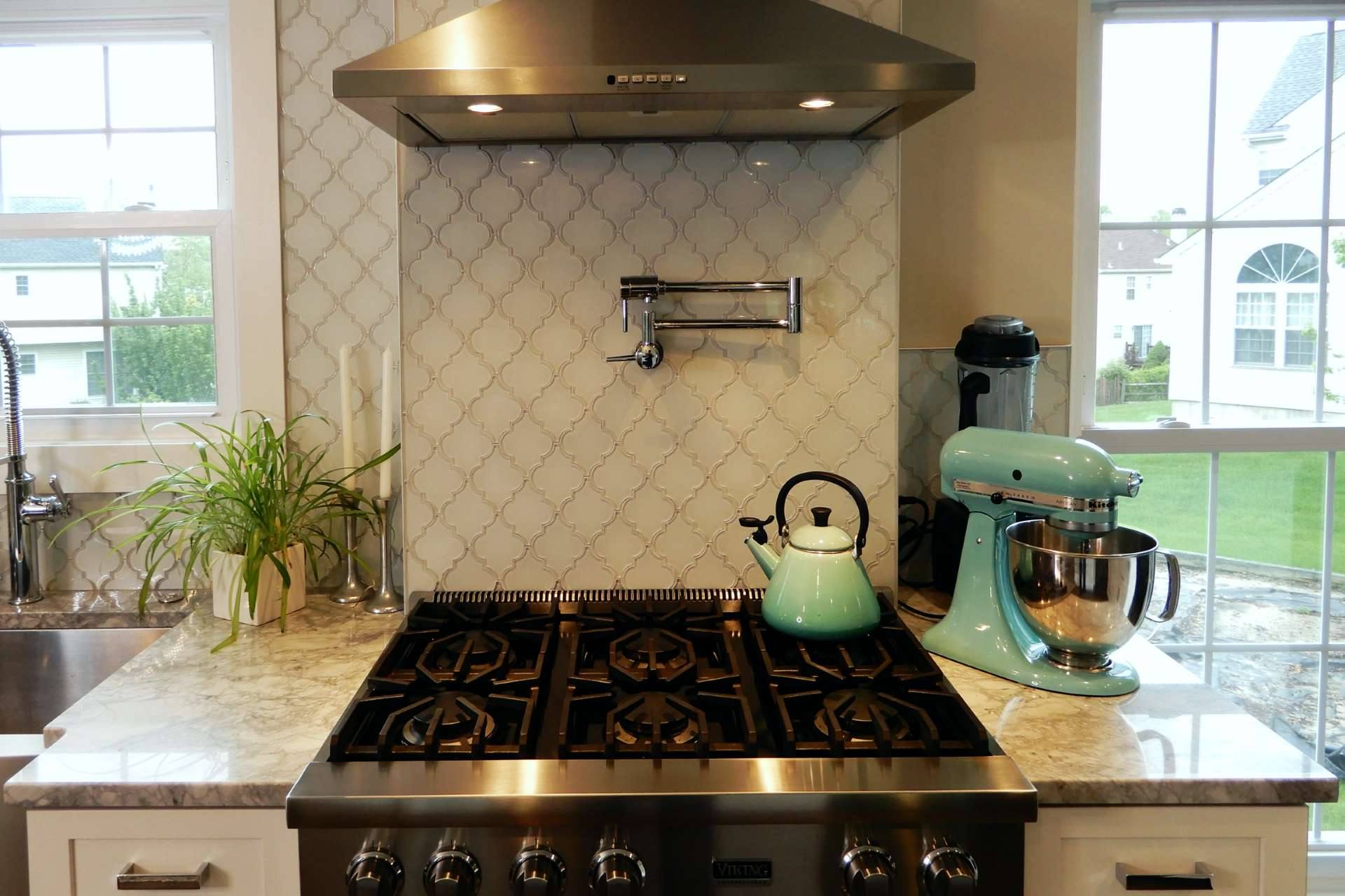 Gas cooktop and pot filler above a Super White quartzite counter