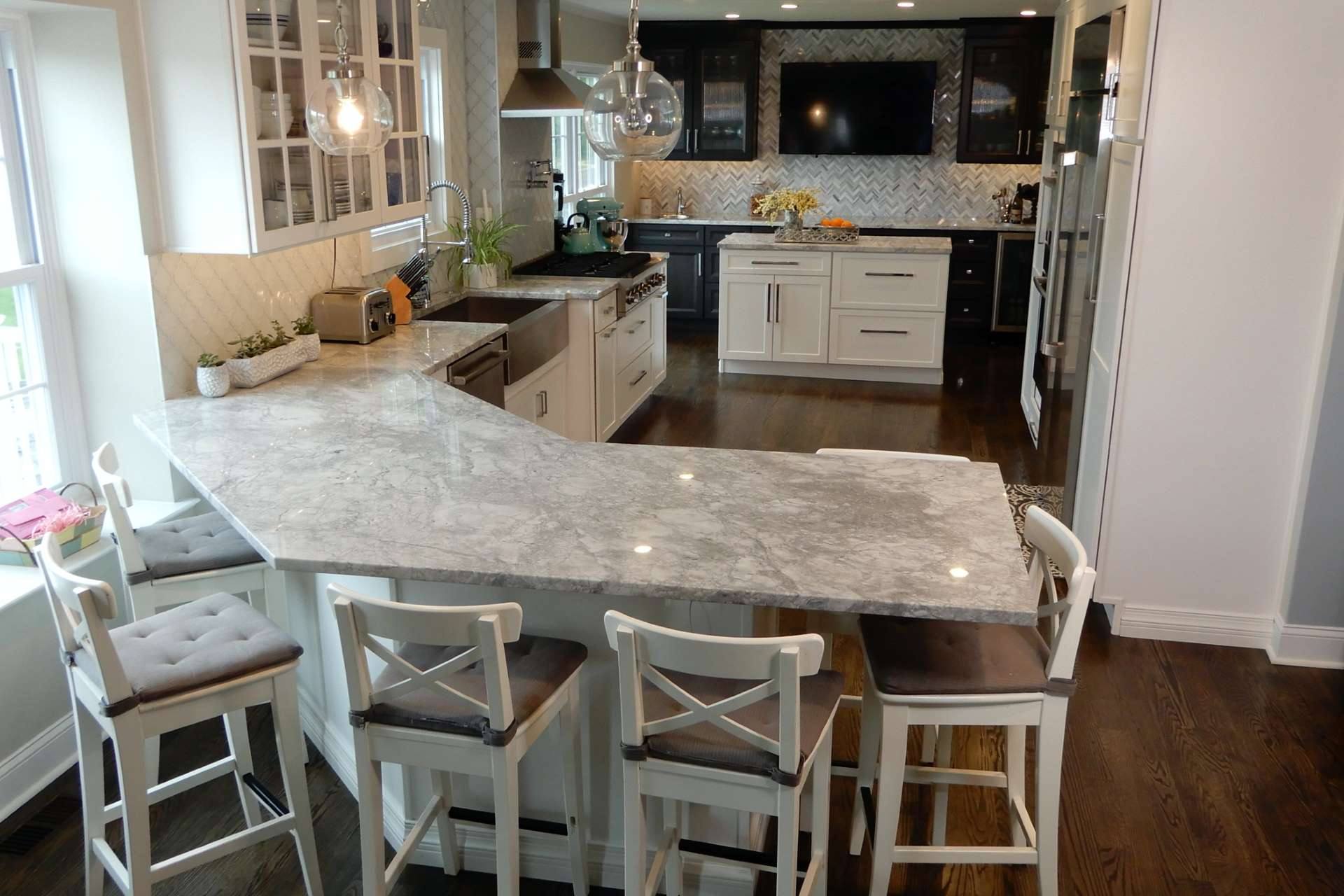 Curved Super White quartzite peninsula with white counter stools