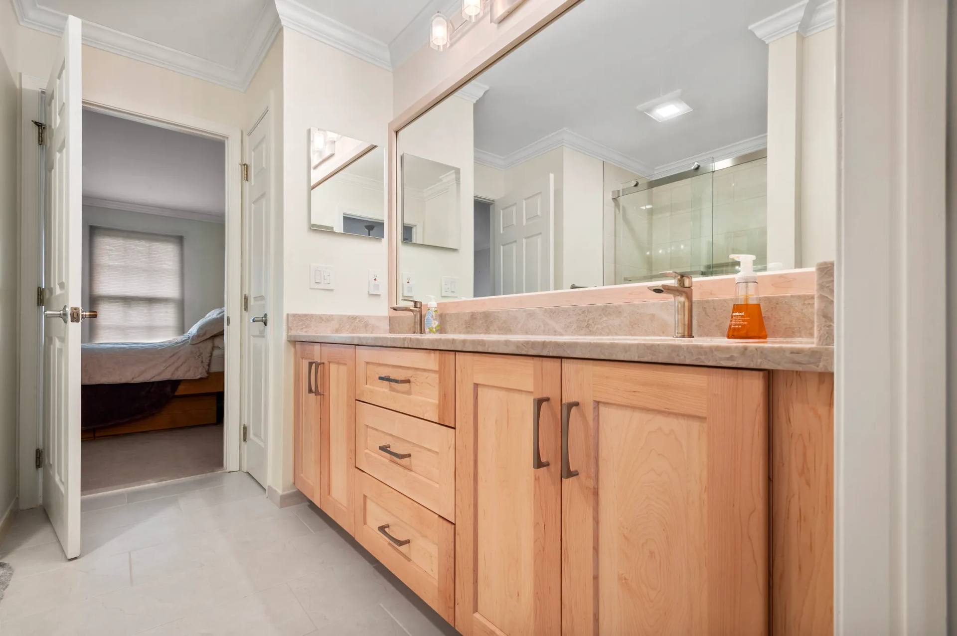 Taj Mahal quartzite double vanity with light wood cabinets below