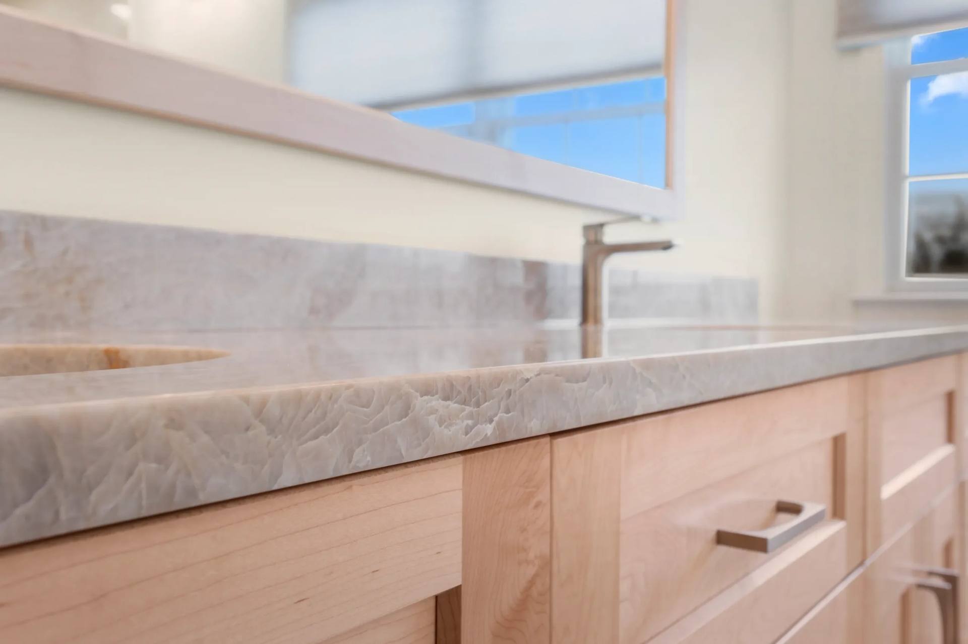 Taj Mahal quartzite vanity top with a matching backsplash below a window