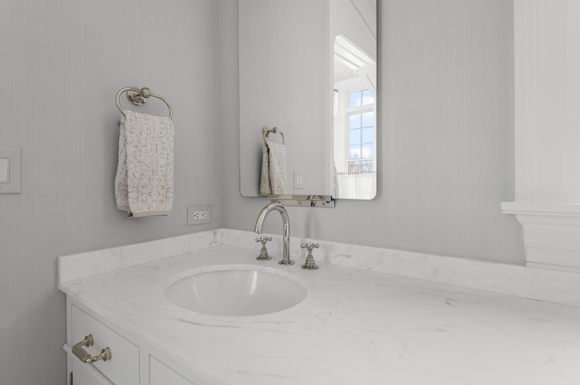 Undermount basin and silver-tone faucet in a Thassos marble top