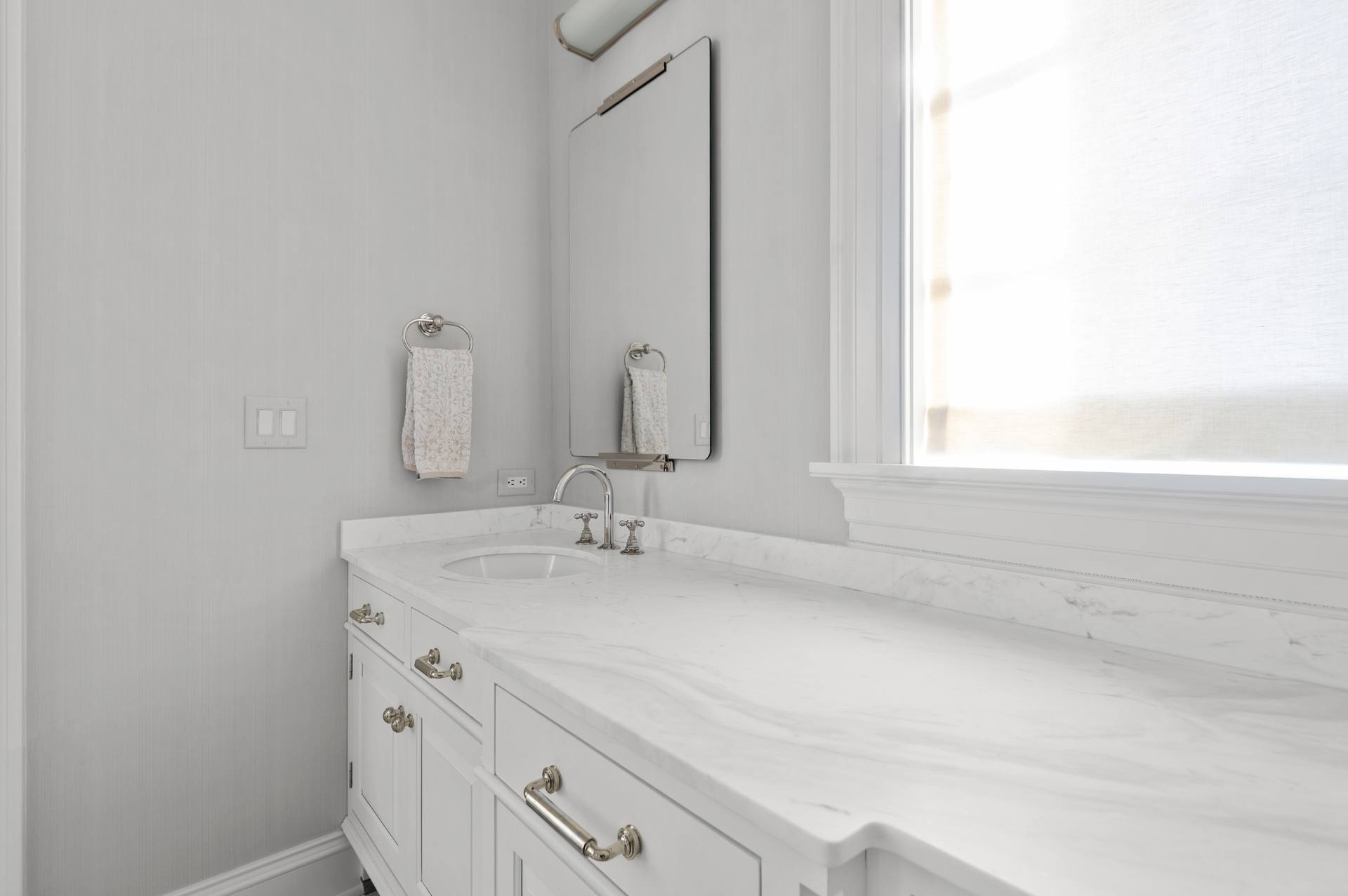 Thassos marble counter running past a basin below a window