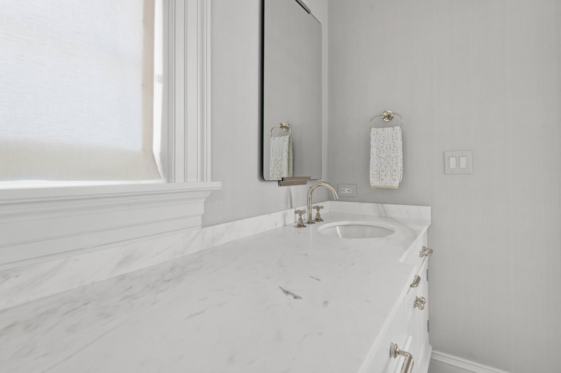 Thassos marble counter turning toward a window with a basin beyond