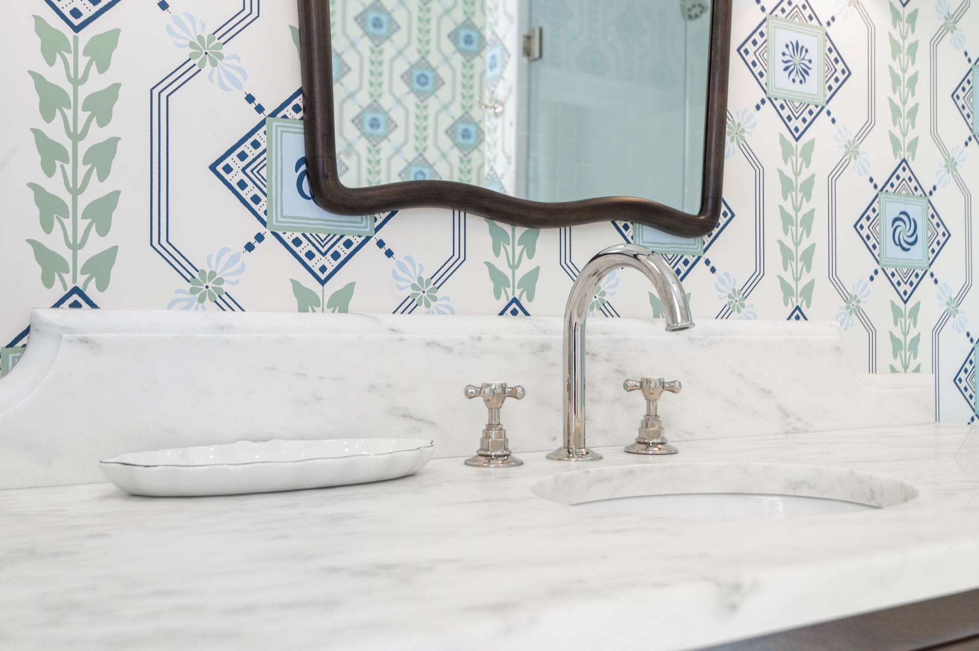 Silver-tone cross-handle faucet set into a White Carrara marble top
