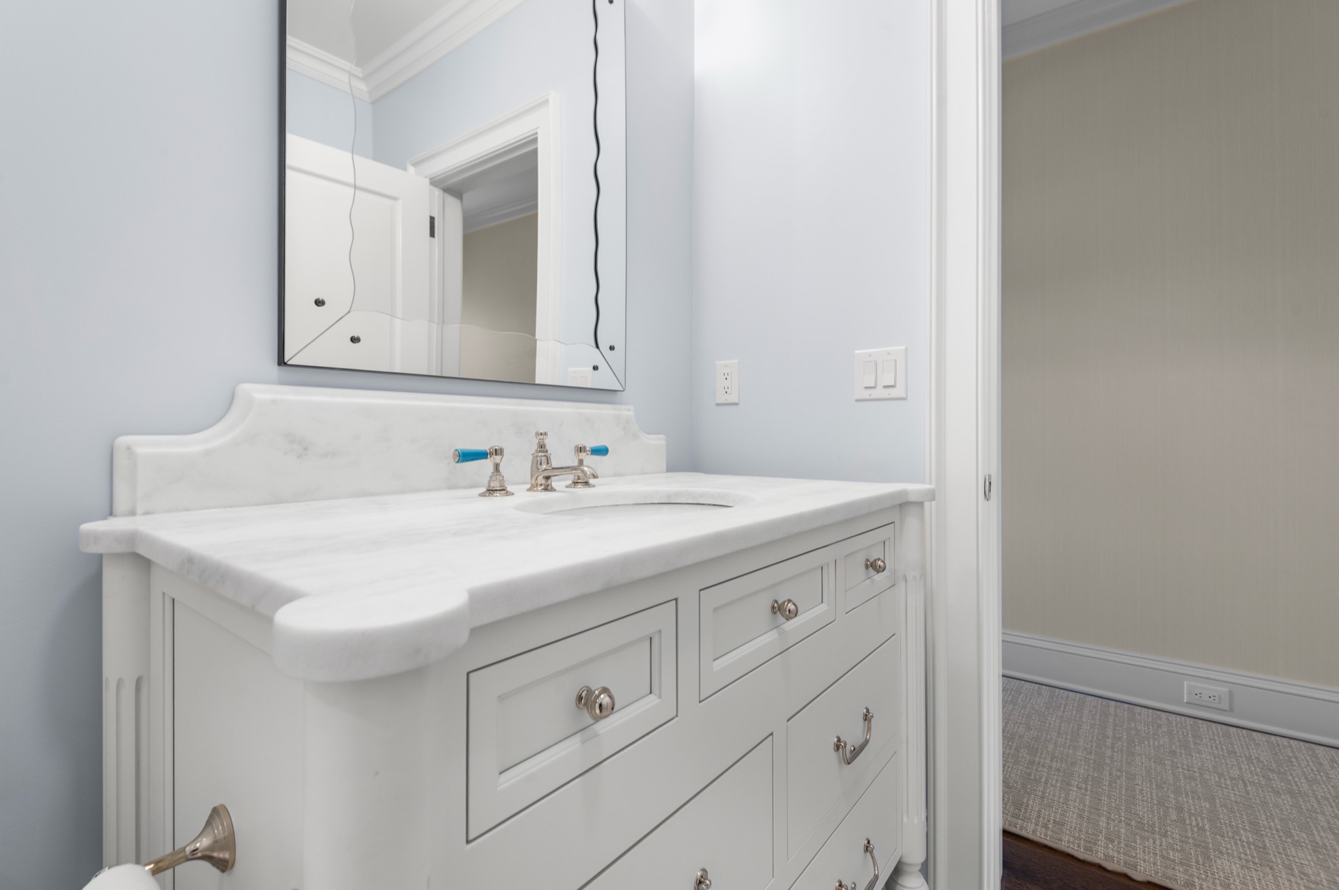 White Carrara marble vanity top viewed from the bathroom doorway