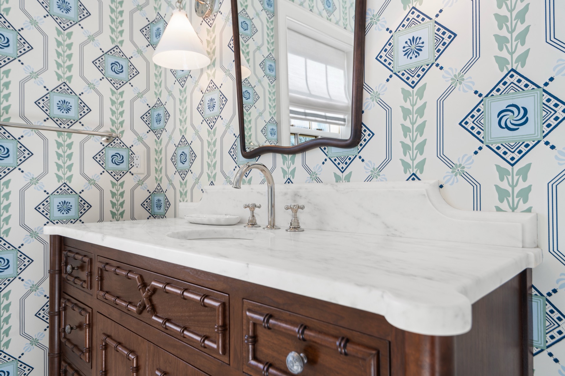 White Carrara marble vanity top with a shaped backsplash on a dark wood cabinet