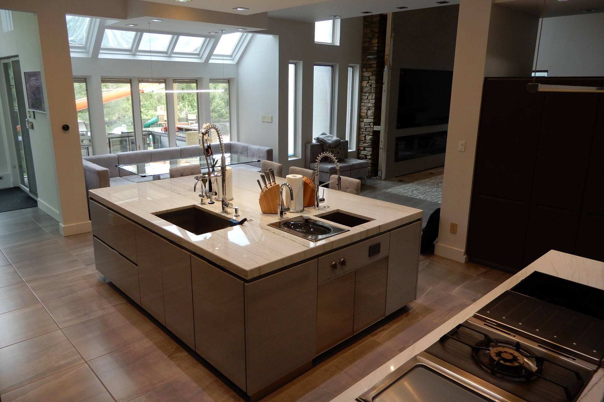 White Macaubas quartzite island looking toward a living area with skylights