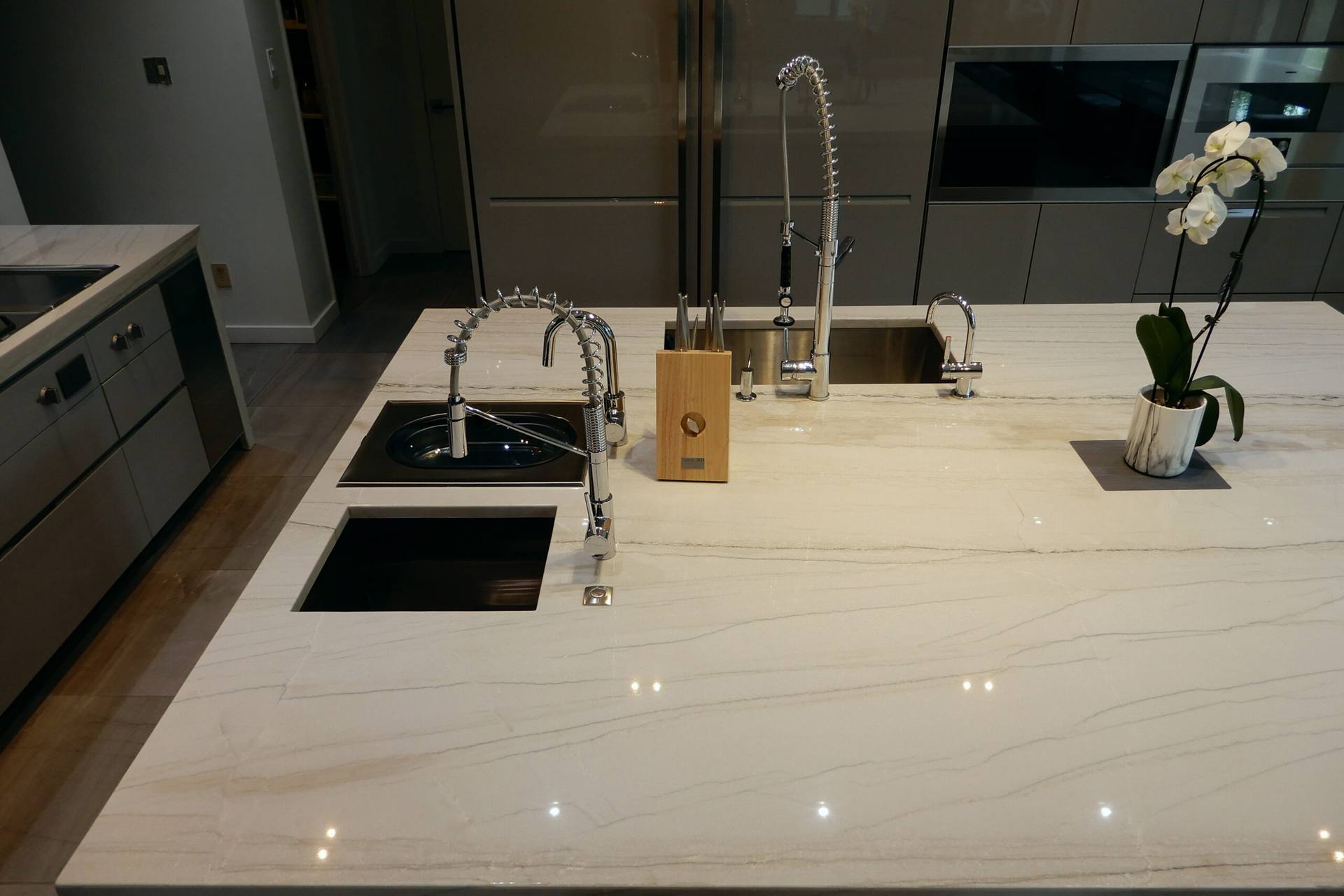 White Macaubas quartzite island top with two sinks and a pull-down faucet