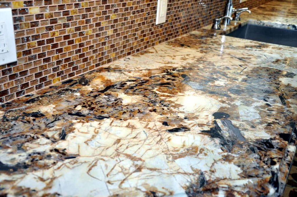 Splendor Gold leathered granite countertop beside a mosaic backsplash