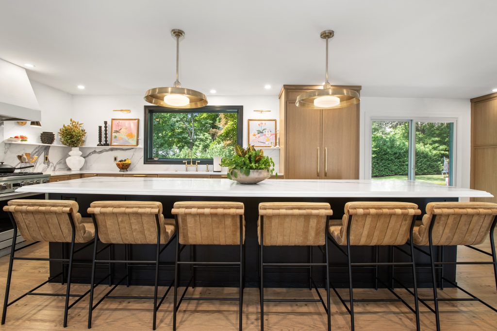 White kitchen with a dark island and light stone countertops