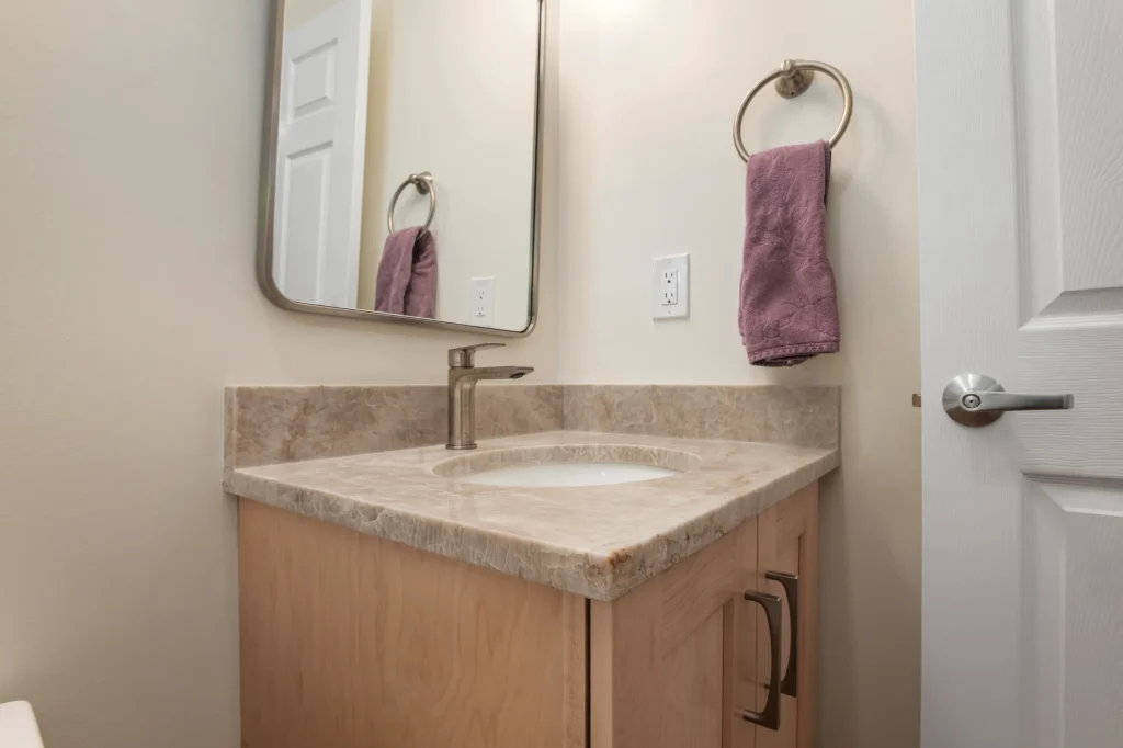 Bathroom vanity with a light stone countertop and undermount sink